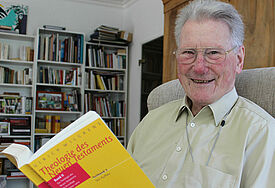 Wilckens mit Buch in seinem Lesezimmer