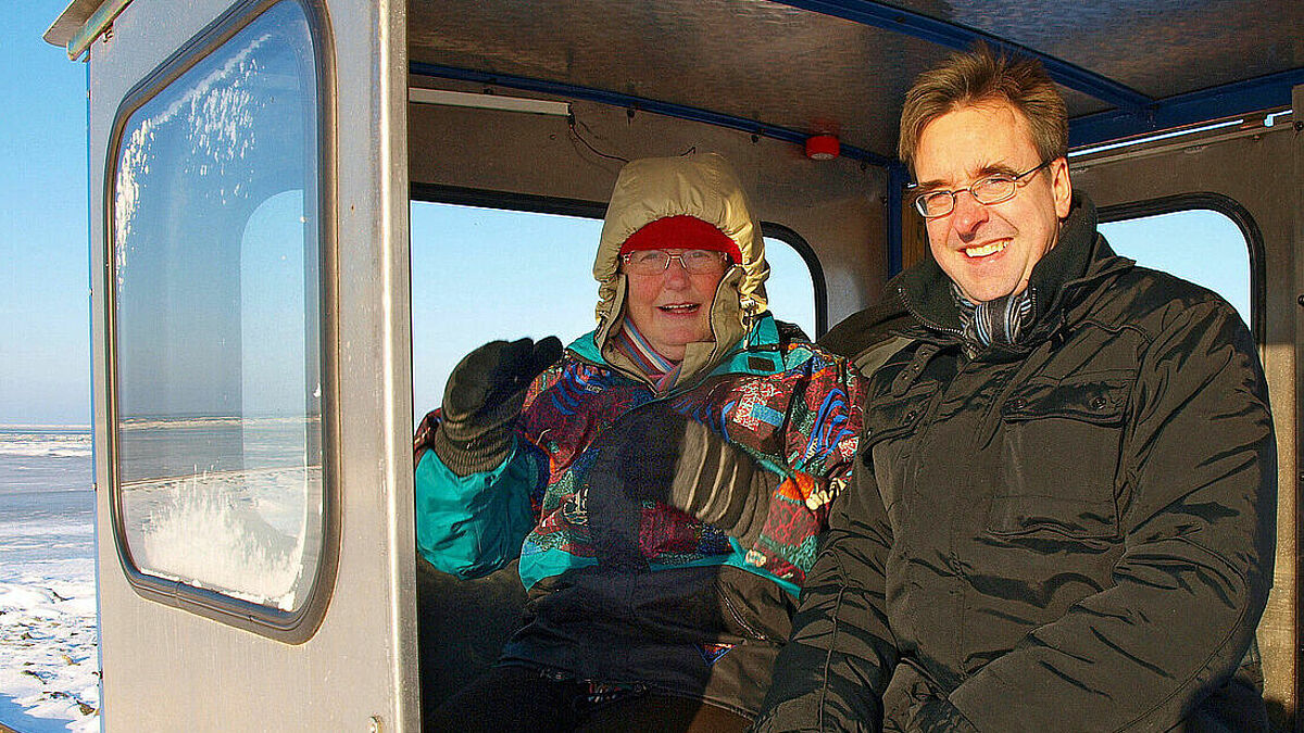 Pastor Thorsten Wiese mit Begleitung auf der Lore nach Nordstrandischmoor (Foto: epd)