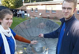 Kochen ohne Strom: Teilnehmer der Jugendklimakonferenz auf dem Koppelsberg bei Plön schauen sich einen Solarkocher an
