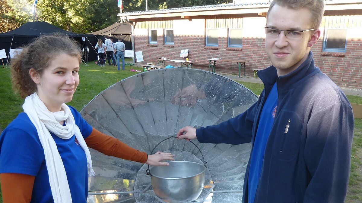 Kochen ohne Strom: Teilnehmer der Jugendklimakonferenz auf dem Koppelsberg bei Plön schauen sich einen Solarkocher an