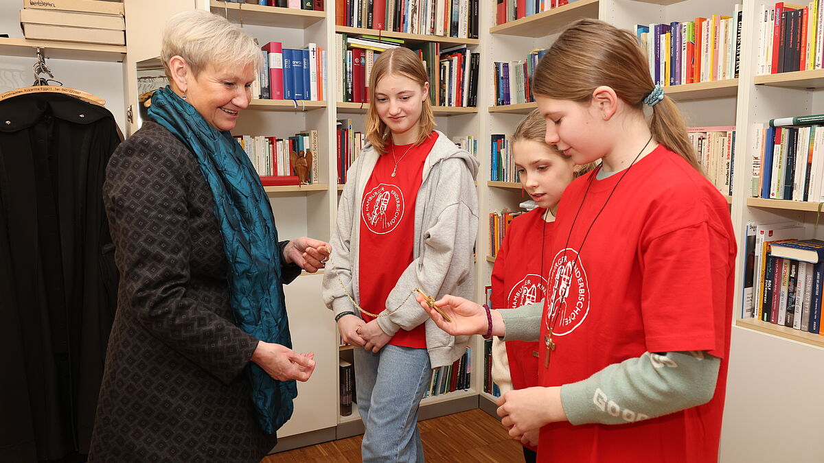 Bischöfin Kirsten Fehrs zeigte ihren "Amtsschwestern" ihr Bischofskreuz. Ehrfurchtsvoll wurde es von allen drei Mädchen in die Hand genommen und begutachtet.