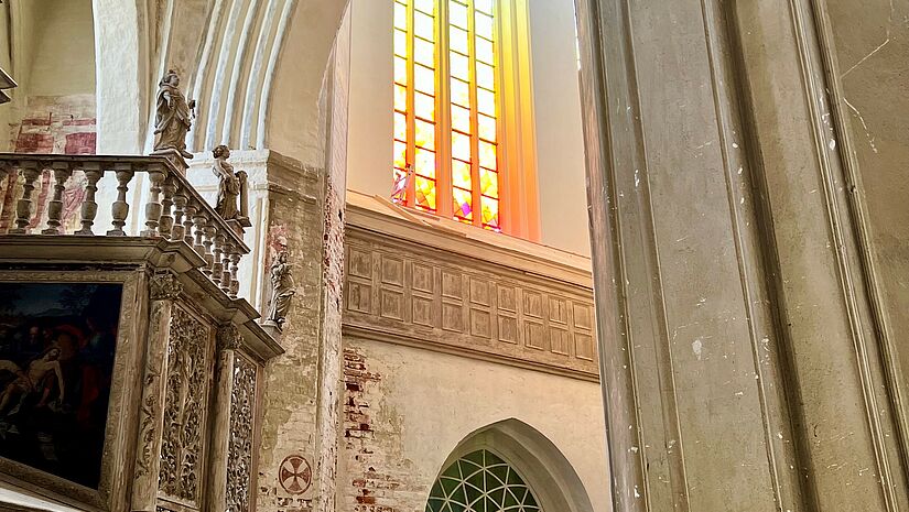 Blick auf das bunte Fenster von der Seite. Das Sonnenlicht lässt die farbigen leuchten.nt durch