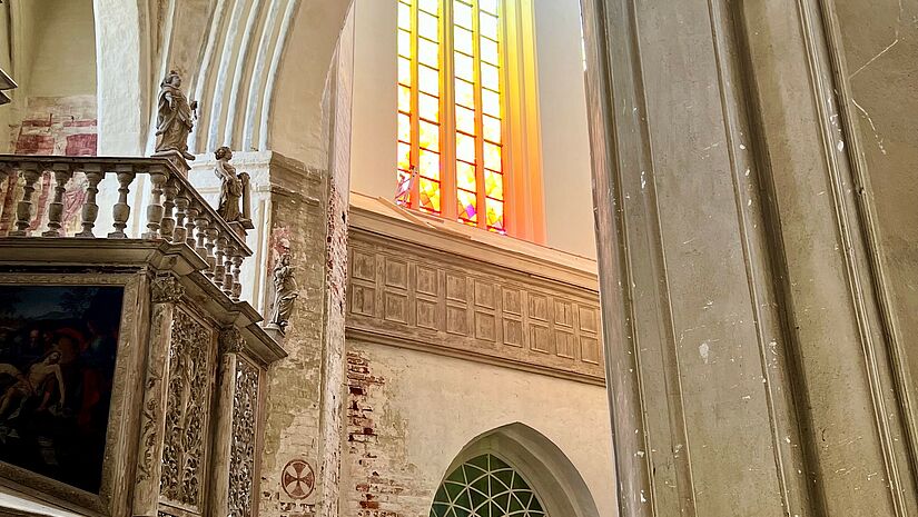 Blick auf das bunte Fenster von der Seite. Das Sonnenlicht lässt die farbigen  leuchten.nt durch 