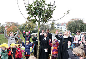 Mit Unterstützung aus Hamburger Kitas pflanzen MArgot Käßmann und Kirsten Fehrs einen Apfelbaum