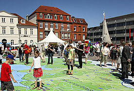 Kinder Spielen beim Gründungsfest auf Karte mit Gebiet der Nordkirche 