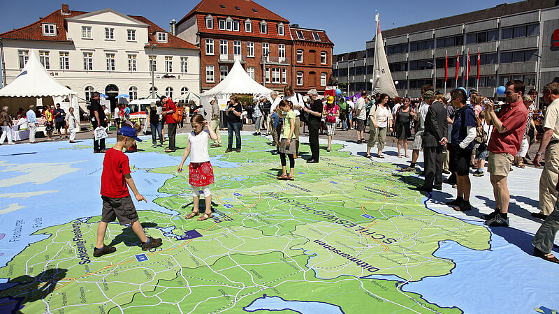 Kinder Spielen beim Gründungsfest auf Karte mit Gebiet der Nordkirche 