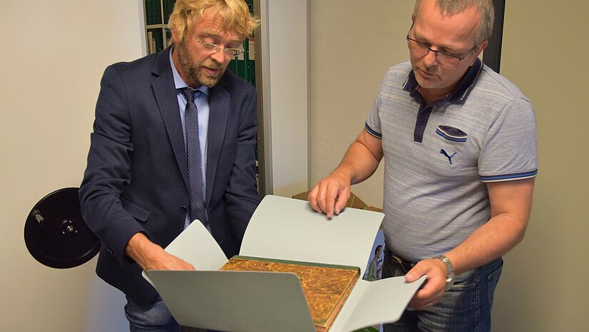 Pastor Mathias Alpen und Gerd Lorenzen, Leiter des Kirchenbüros in Tingleff beim Durchstöbern des Gemeindearchivs (v.l.n.r.)
