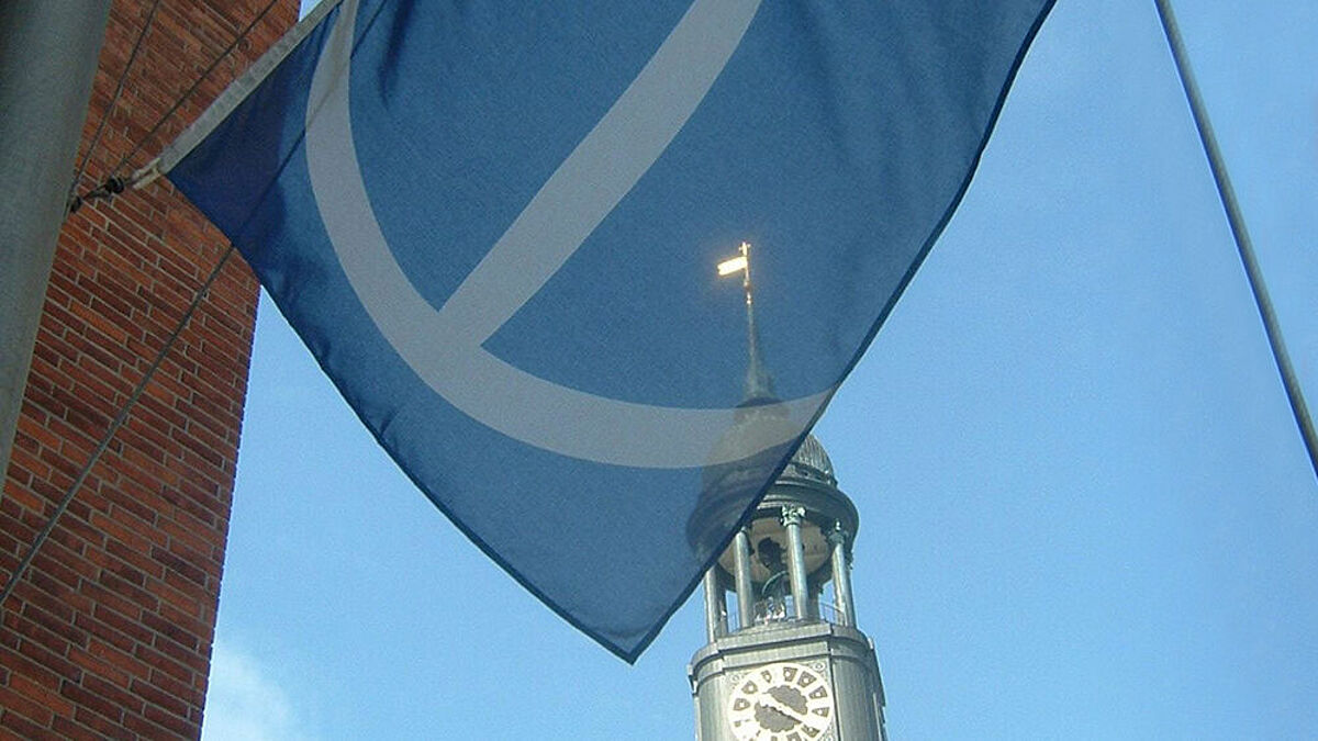 Flagge des Seemannsheims weht im Wind, dahinter sieht man die Spitze des Michels