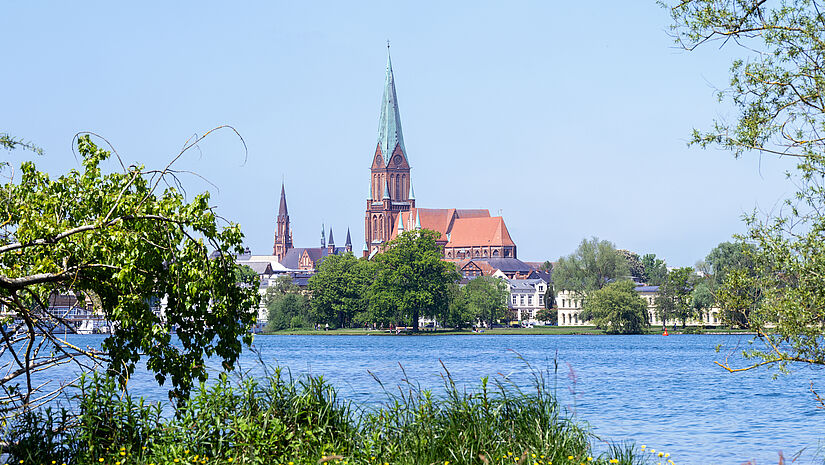 Der Schweriner ist eines der frühesten großen Beispiele backsteingotischer Architektur, hier vom Seeufer in der Landeshauptstadt Mecklenburg-Vorpommern aus gesehen.