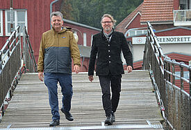 Pastor Dirk Homrighausen (l.) und Pastor Ole Halley gehen gemeinsam über eine Brücke in Eckernförde.