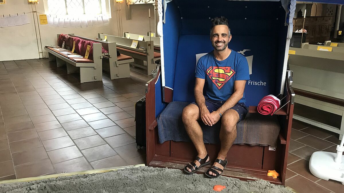 Pastor Steffen Paar hat es sich im Strandkorb der Sülfelder Kirche bequem gemacht.
