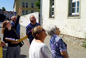 Eine Gruppe Menschen steht auf der Straße und blickt zur Außenfassade des Jagdschlosses in Pasewalk.