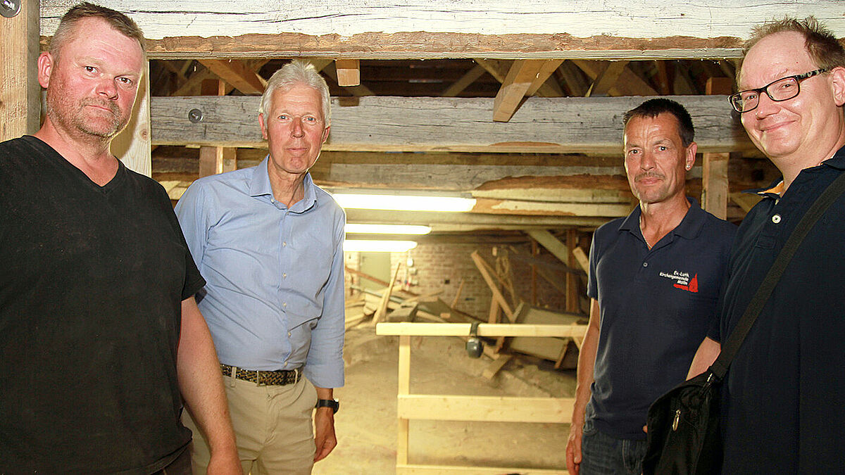 Zimmererpolier Frank Pfefferkorn (v.l.), Architekt Torsten Ewers, Küster Jörg Fischer und Pastor Matthias Lage über dem Kirchengewölbe von St. Nicolai in Mölln