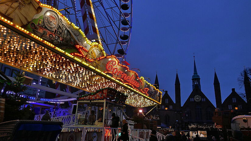 Riesenrad auf dem maritimen Weihnachtsmarkt in Lübeck. Die Lichter eines Riesenrads leuchten hell in der Dunkelheit auf dem maritimen Weihnachtsmarkt in Lübeck.