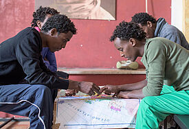 Eritreische Flüchtlinge blicken auf eine Europakarte
