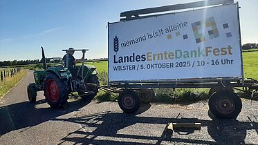 Traktor mit einem Banner des Landeserntedankfestes 2025 in Wilster