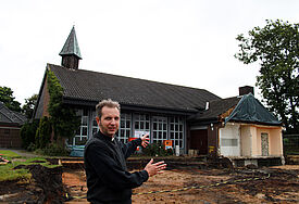 Pastor Tobias Jäger zeigt die Baugrube für die neue Kirche seiner Gemeinde in Barmstedt (C) Döllefeld, Evangelische Zeitung