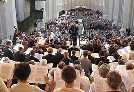 Blick über die Schulter der Chorsänger in den gut besuchten Greifswalder Dom während eines Gottesdienstes.