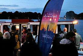Eine Alsterfahre legt zur Nacht der Kirchen in Hamburg an einem Steg an.