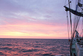 Das Nordkirchenschiff segelt in den Sonnenaufgang über der Nordsee.