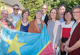 Gruppe Menschen, die die eine große kongolesische Flagge hält