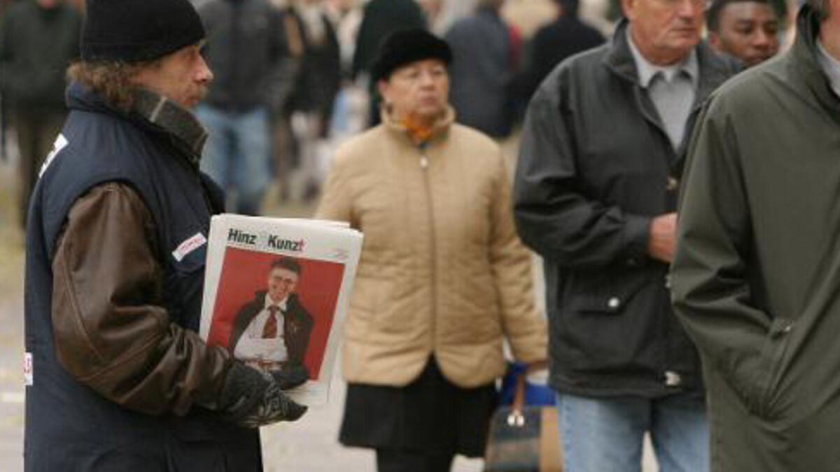 Ein Verkäufer der Hamburger Obdachlosenzeitung Hinz und Kunzt bietet auf dem Jungfernstieg in Hamburg Passanten die Zeitung zum Kauf an.