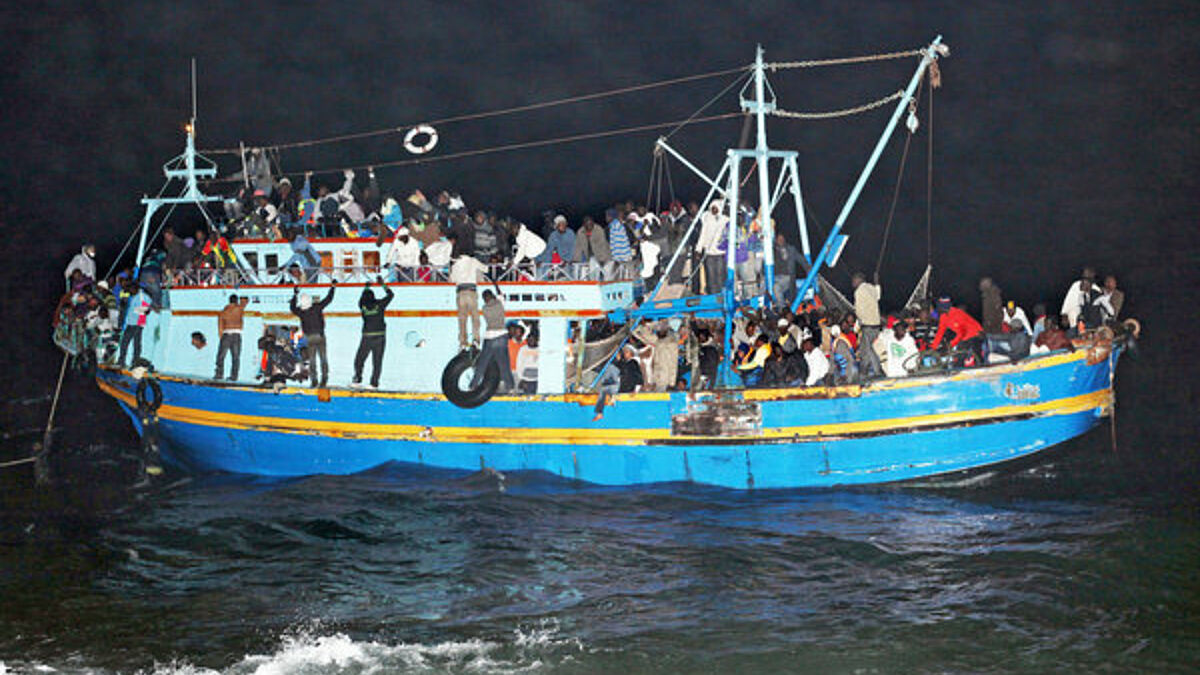 Ein mit etwa 500 Flüchtlingen überladenes Boot aus Libyen läuft nachts vor Lampedusa auf Grund (Mai 2011). Mit Booten wie diesem sind auch die in Hamburg gestrandeten Flüchtlinge über das Mittelmeer nach Italien geflohen. 