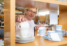 Rita Schneider platziert ein gespendetes Kaffeeservice im Sozialkaufhaus in Ahrensburg.