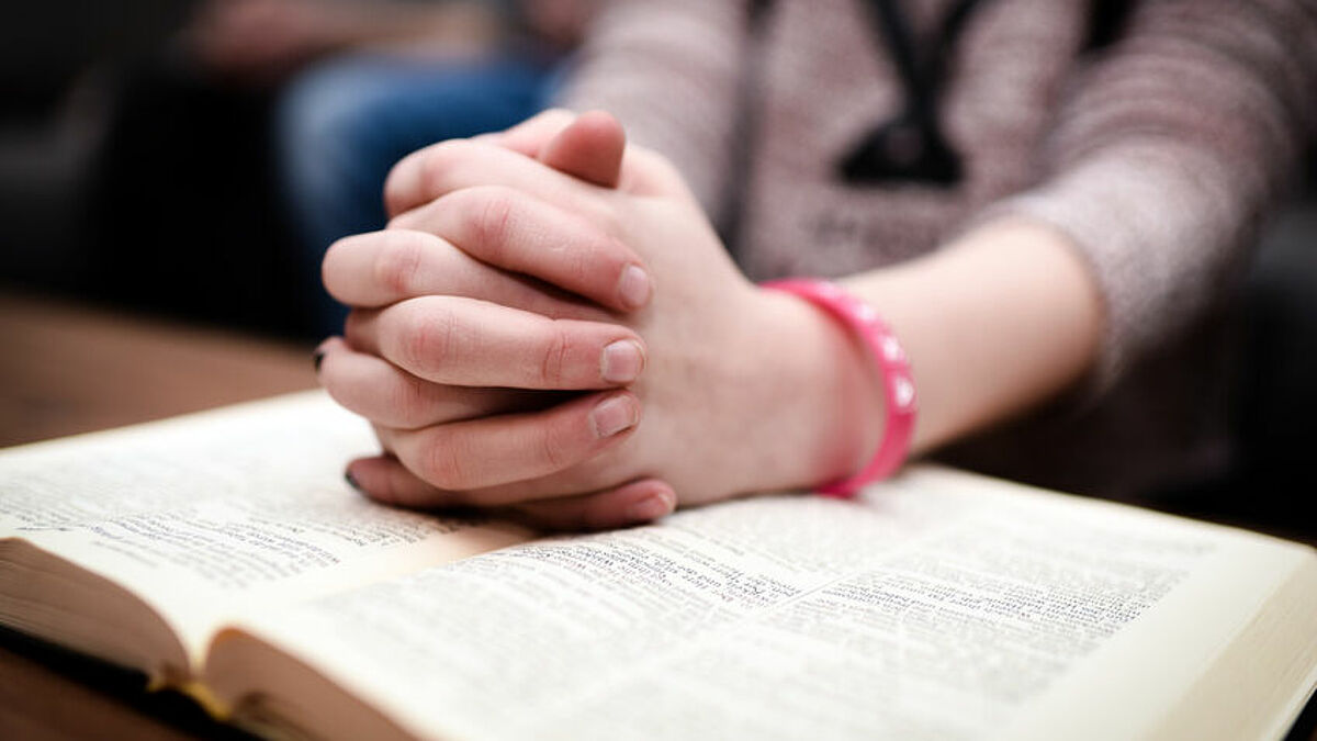 Betende Hände über Bibel