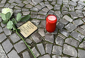 Stolperstein mit Rose und Kerze in Greifswald 