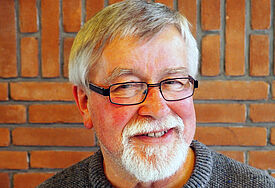 Porträt von Wolfgang Müller, Mann mit Brille, weißen Haaren und weißem Bart
