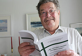 Manfred Kamper hält in der Hand die Neuausgabe der Breklumer Hefte