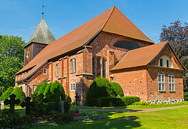 Backsteinkirche inmitten von Grün