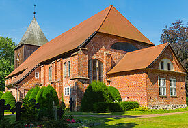 Backsteinkirche inmitten von Grün