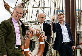 Propst Thomas Lienau-Becker (v. l.), Bischof Gothart Magaard und Ministerpräsident Daniel Günther an Bord des Nordkirchenschiffs