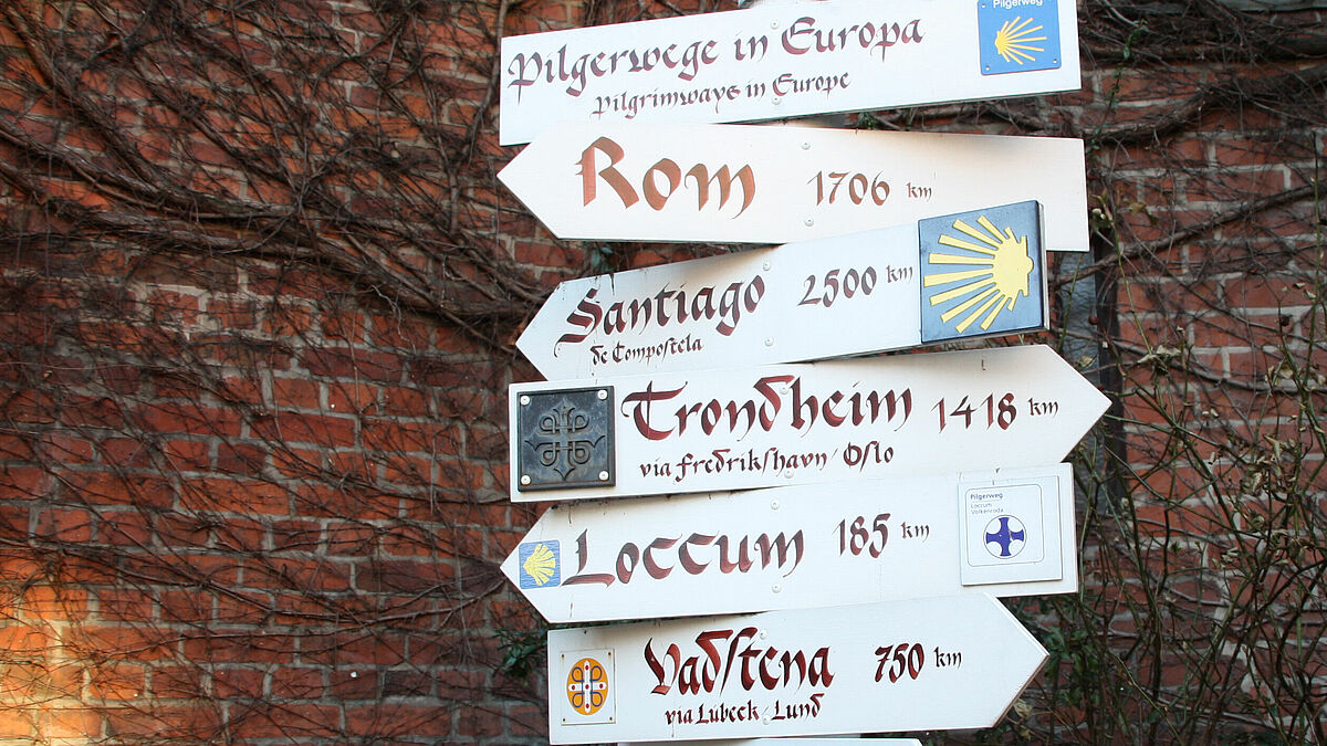 Ein Wegweiser vor der Hamburger Hauptkirche St. Jacobi zeigt Pilgern Ziele in ganz Europa an.