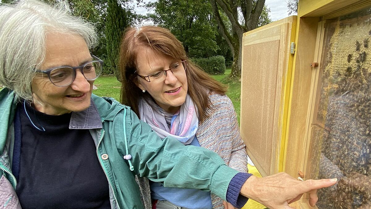 Dorothea Tilge, Imkerin und Kirchengemeinderätin (links) und Friedhofswartin Dörte Rausch zeigen das Bienenvolk des Kuddewörder Friedhofs. Es wurde dort in diesem Sommer angesiedelt. 
