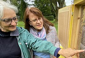 Dorothea Tilge, Imkerin und Kirchengemeinderätin (links) und Friedhofswartin Dörte Rausch zeigen das Bienenvolk des Kuddewörder Friedhofs.