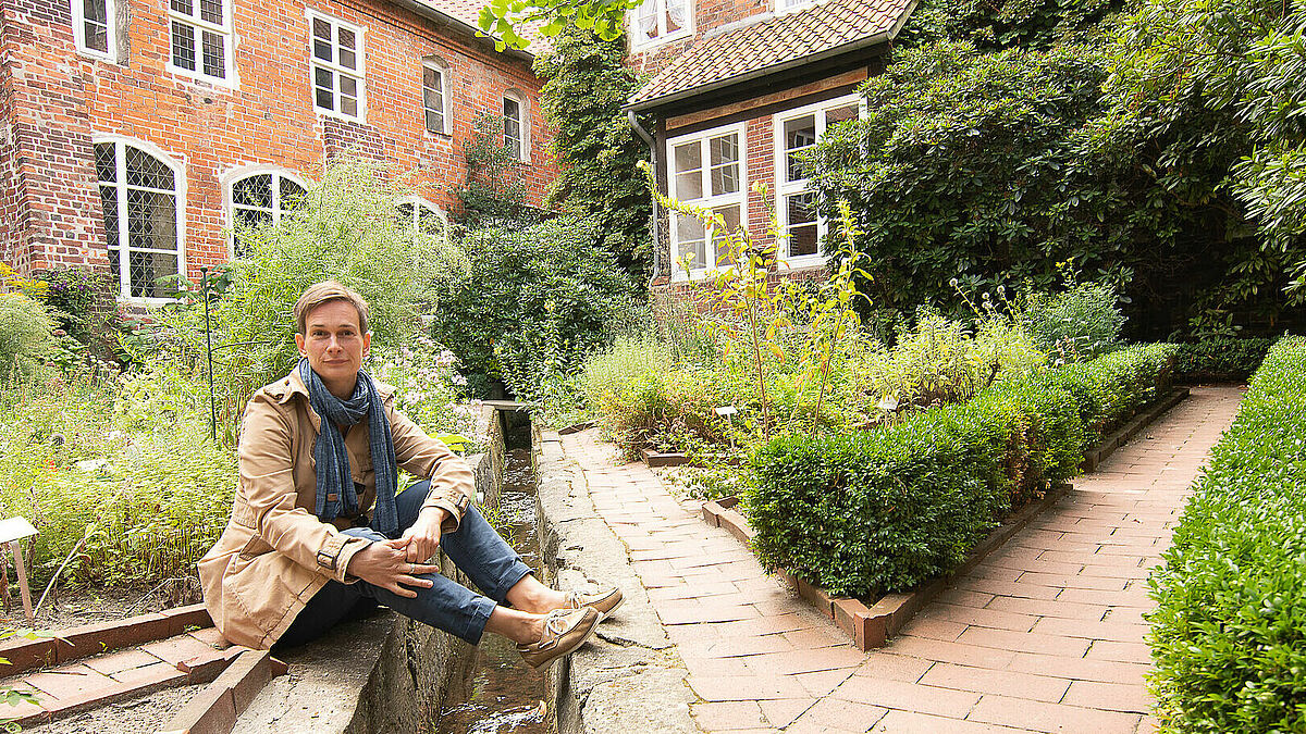 Carolin George sitzt im Kräutergarten des evangelischen Frauenklosters Lüne bei Lüneburg