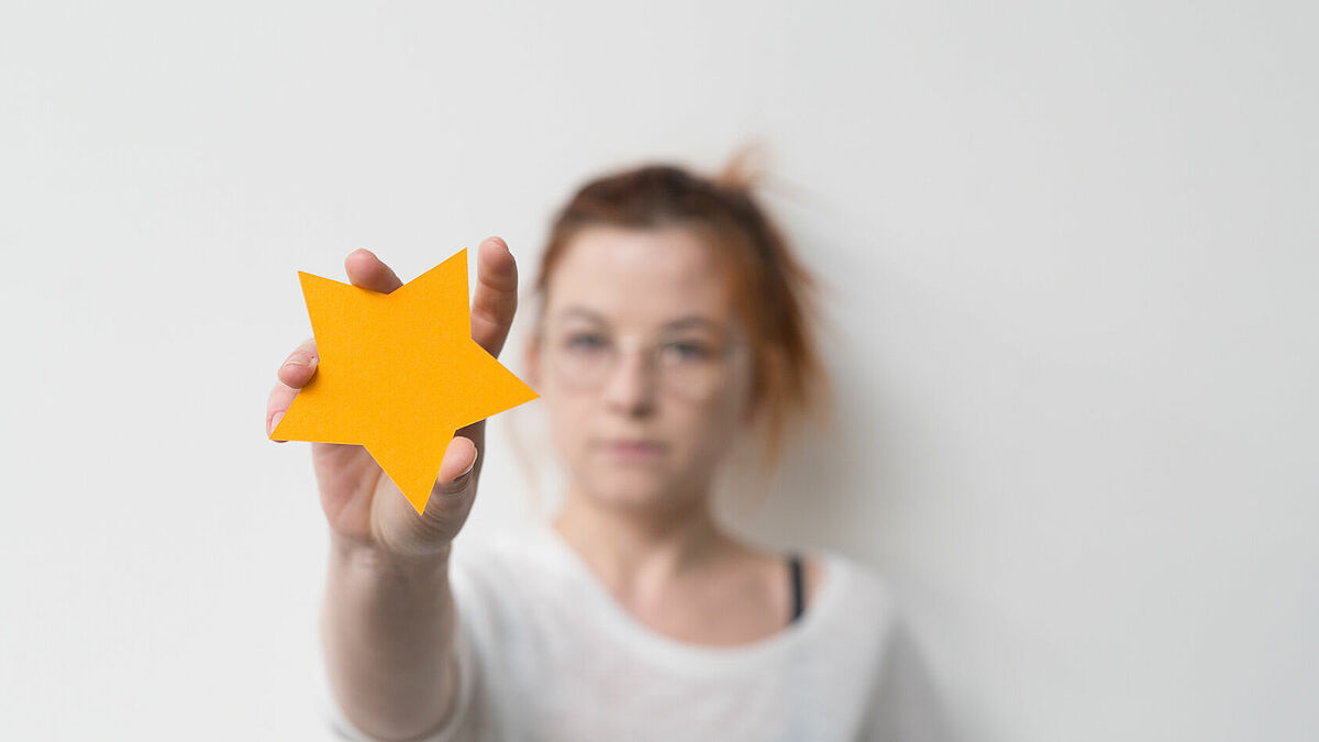 Frau greift nach Stern
