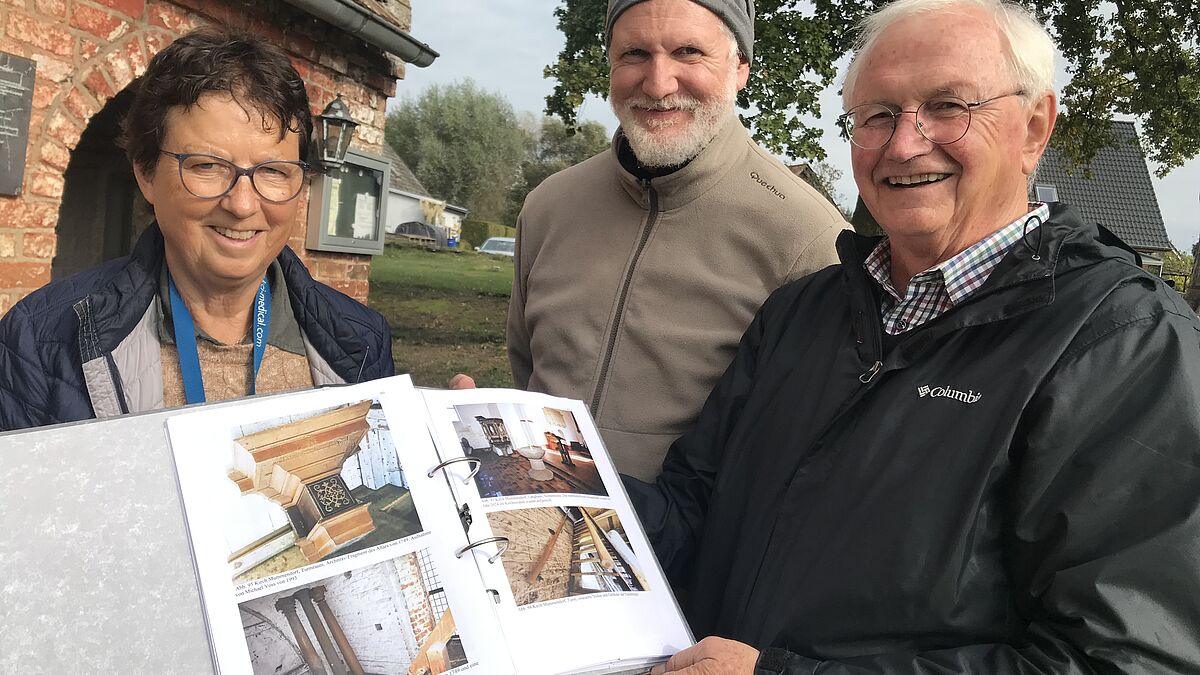 Ralf Gesatzky (rechts) übergibt seinen Untersuchungsbericht an Franziska Czygan und Chris Böhler vom Förderkreis der Kirche von Kirch Mummendorf.