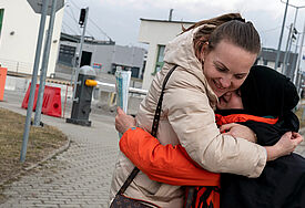 Eine Mutter nimmt ihren Sohn am Grenzübergang fest in den Arm.