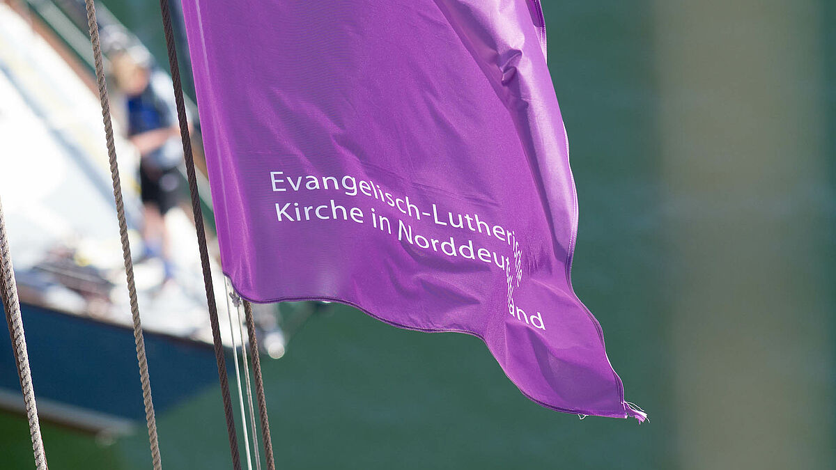 Die Fahne der Nordkirche weht in der Takelage des Nordkirchenschiffs.