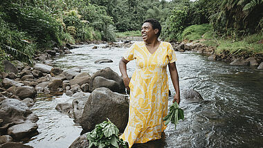 Luisa Curuki (35) Vorsitzende Womens‘ Club, waescht Bele-Blaetter im Fluss hinter ihrem Haus. Der Partner von Brot fuer die Welt, FCOSS (Fiji Council of Social Services) unterstuetzt die Umsiedlung des Dorfes Cogea. Cogea wurde vom Zyklon "Yasa" Ende 2020 zerstoert.
