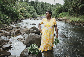 Luisa Curuki (35) Vorsitzende Womens‘ Club, waescht Bele-Blaetter im Fluss hinter ihrem Haus. Der Partner von Brot fuer die Welt, FCOSS (Fiji Council of Social Services) unterstuetzt die Umsiedlung des Dorfes Cogea. Cogea wurde vom Zyklon "Yasa" Ende 2020 zerstoert.