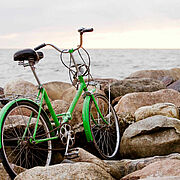 Ein grünes Fahrrad am Strand