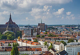 Blick auf die Hansestadt Rostock mit Häusern, Kirchtürmen und Ostsee.