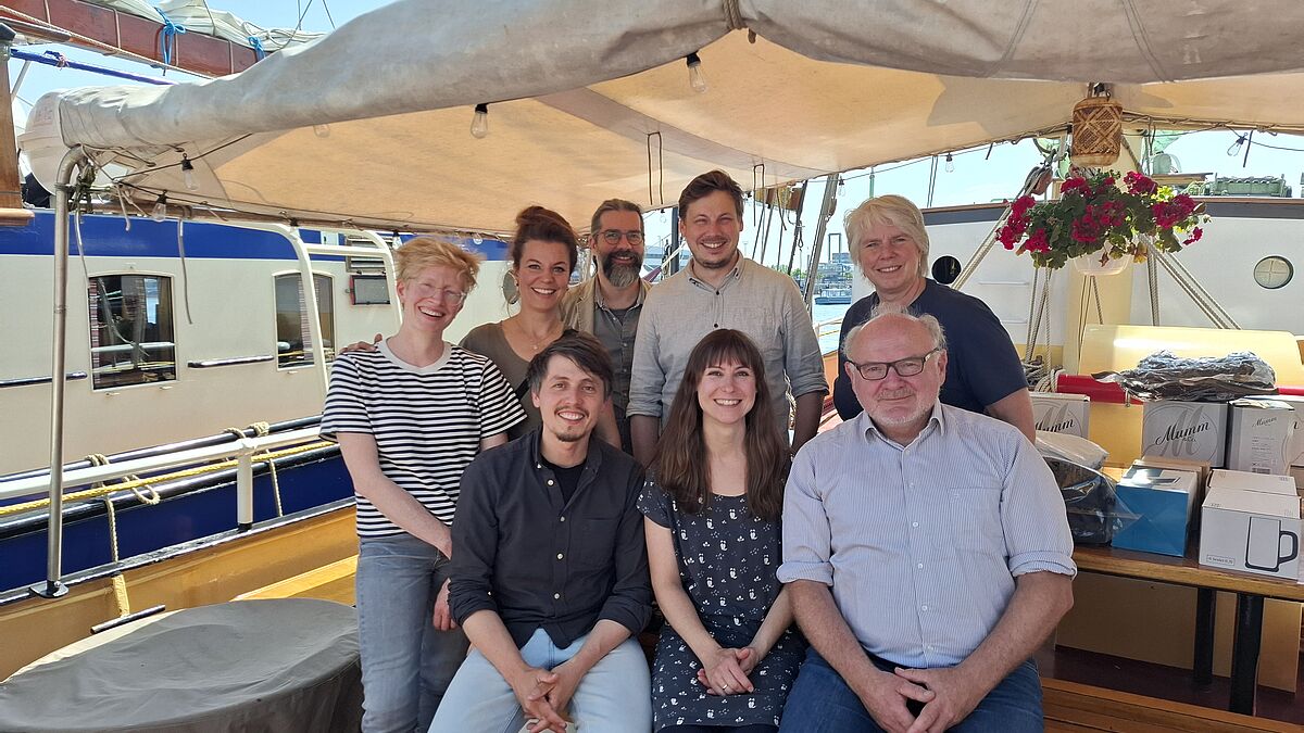 Der Dreimastschoner ist für die Tournee im Sommer 2026 bereits gebucht, das Team hat schon die Aufführungen geplant. 
v.l.(sitzend)  Ron Zimmering, Regisseur, Steffi Harms und Christoph Bauch, Junge Nordkirche, 
(stehend) Alicia Geugelin, Musikalische Leitung, Luise Klafs vom Kulturhimmel, Roman Röpsdorff, Diakon und Schauspieler, Kirchenkreis Hamburg-Ost,  Dennis Bischoff, Leitung Popinstitut der Nordkirche und Doris Hamer von Kirche und Tourismus.