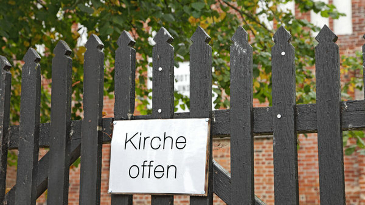 Schild "Kirche offen" am Tor zum Kirchhof der Dorfkirche Wusterhusen in Mecklenburg-Vorpommern. Es lädt Urlauber, Gäste und Durchreisende zum Besuch der Kirche ein.