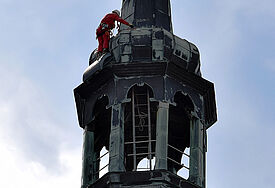 Industriekletterer Falko Weise-Schmidt inspiziert knapp unterhalb der Spitze das Kupferdach des Turms des Greifswalder Doms